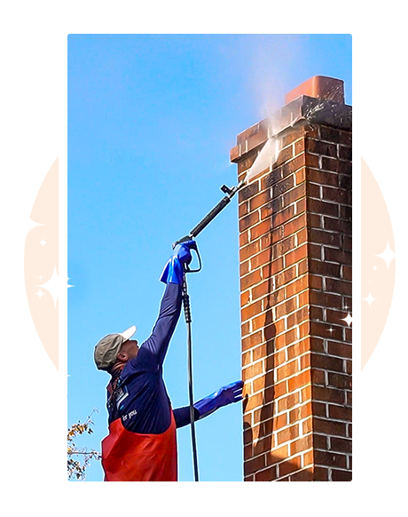 Professional exterior cleaning technician on roof pressure washing brick chimney in Downingtown PA — expert house washing and chimney cleaning services, fully insured